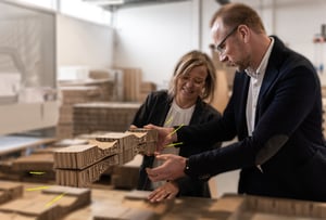 Mitarbeiter von NEXTPACK zeigt Kundin Verpackung aus Wabenpappe