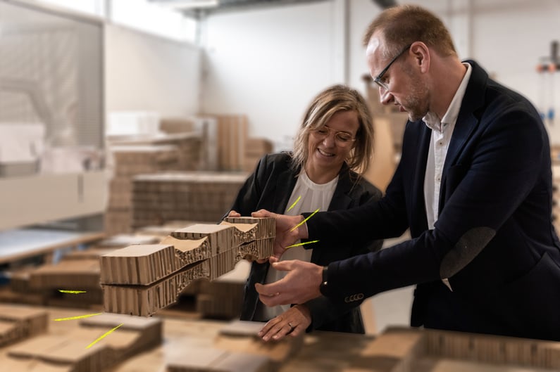 Mitarbeiter von NEXTPACK zeigt Kundin Verpackung aus Wabenpappe