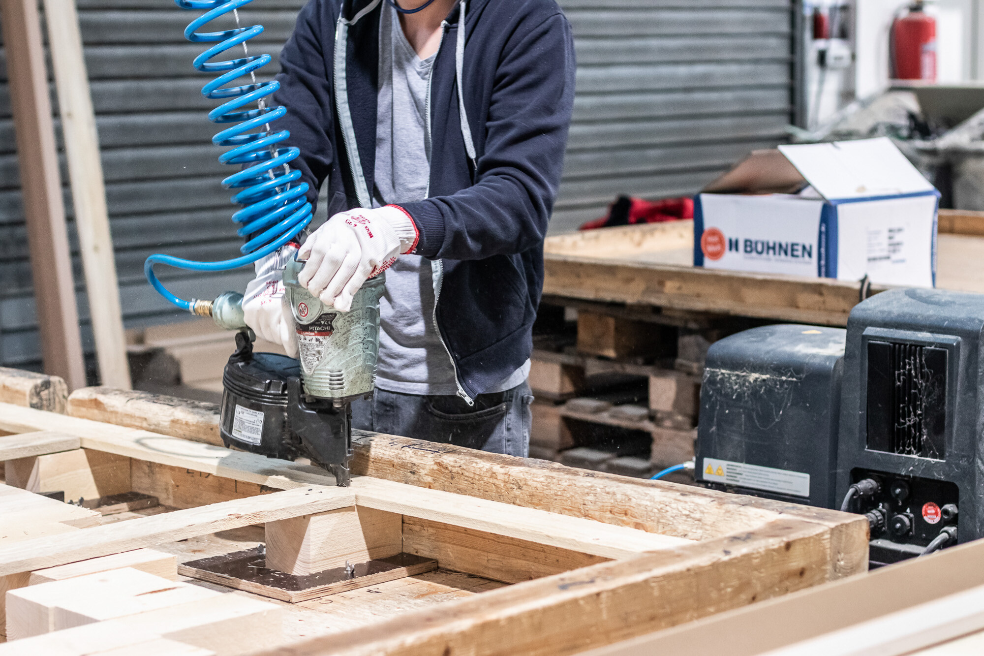 Mitarbeiter von NEXTPACK, welcher eine Palette aus Holz zusammennagelt